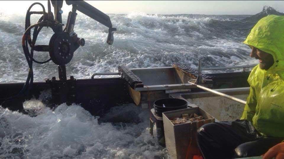 A CrabStar founder working the deck of a commercial crab boat in heavy seas